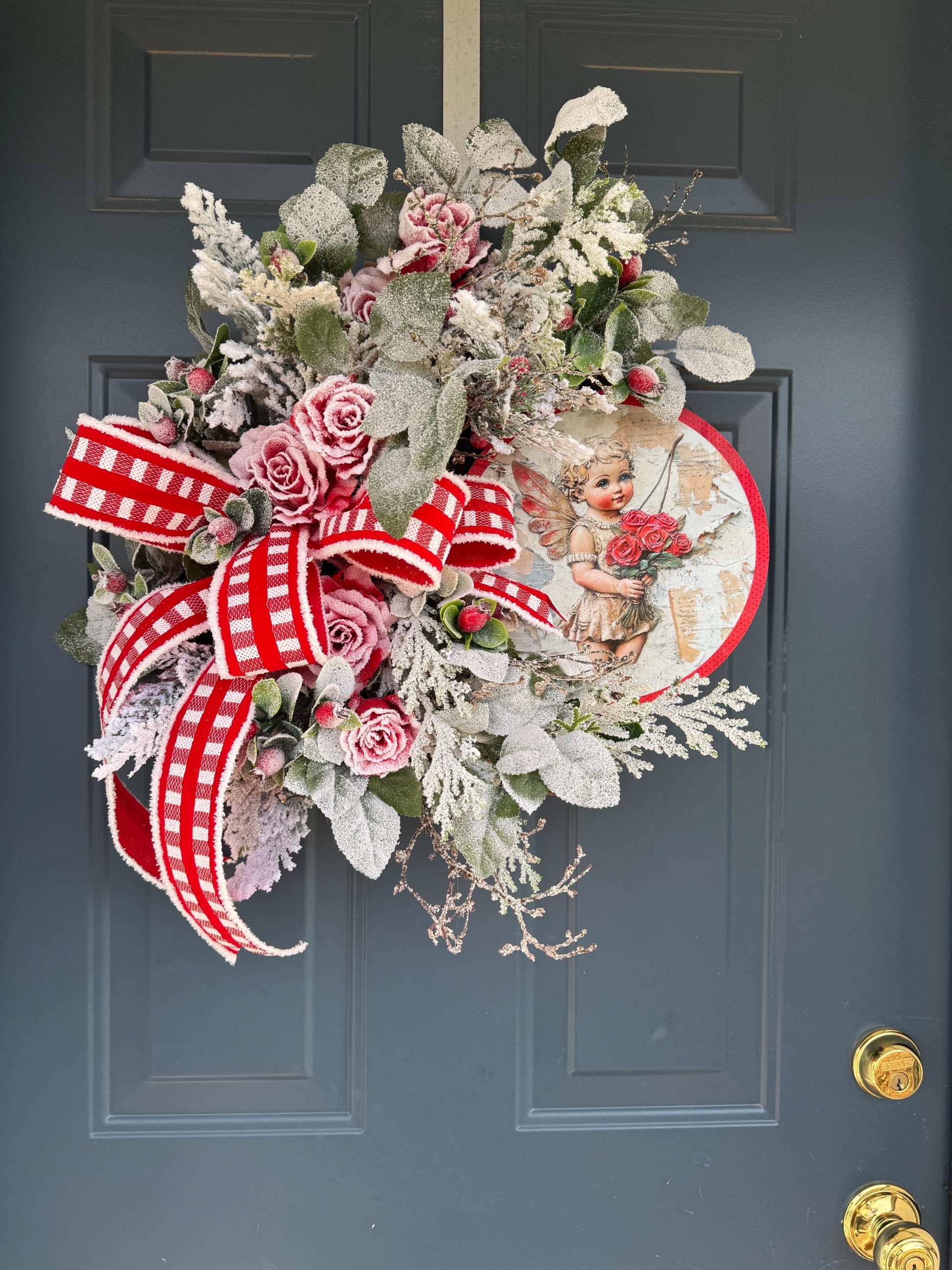 Romantic Valentines Wreath with Cherub Cupid Featuring Snowy Red Roses and Greenery