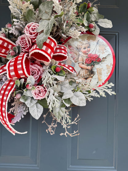 Romantic Valentines Wreath with Cherub Cupid Featuring Snowy Red Roses and Greenery