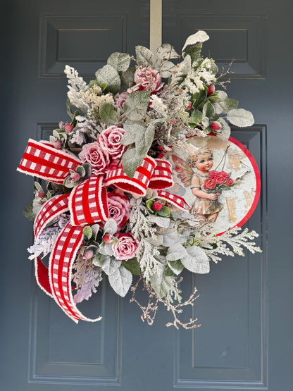 Romantic Valentines Wreath with Cherub Cupid Featuring Snowy Red Roses and Greenery