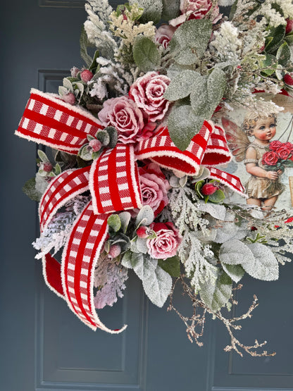 Romantic Valentines Wreath with Cherub Cupid Featuring Snowy Red Roses and Greenery