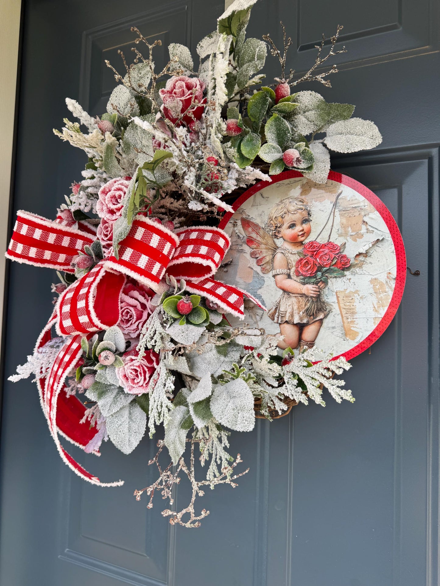 Romantic Valentines Wreath with Cherub Cupid Featuring Snowy Red Roses and Greenery