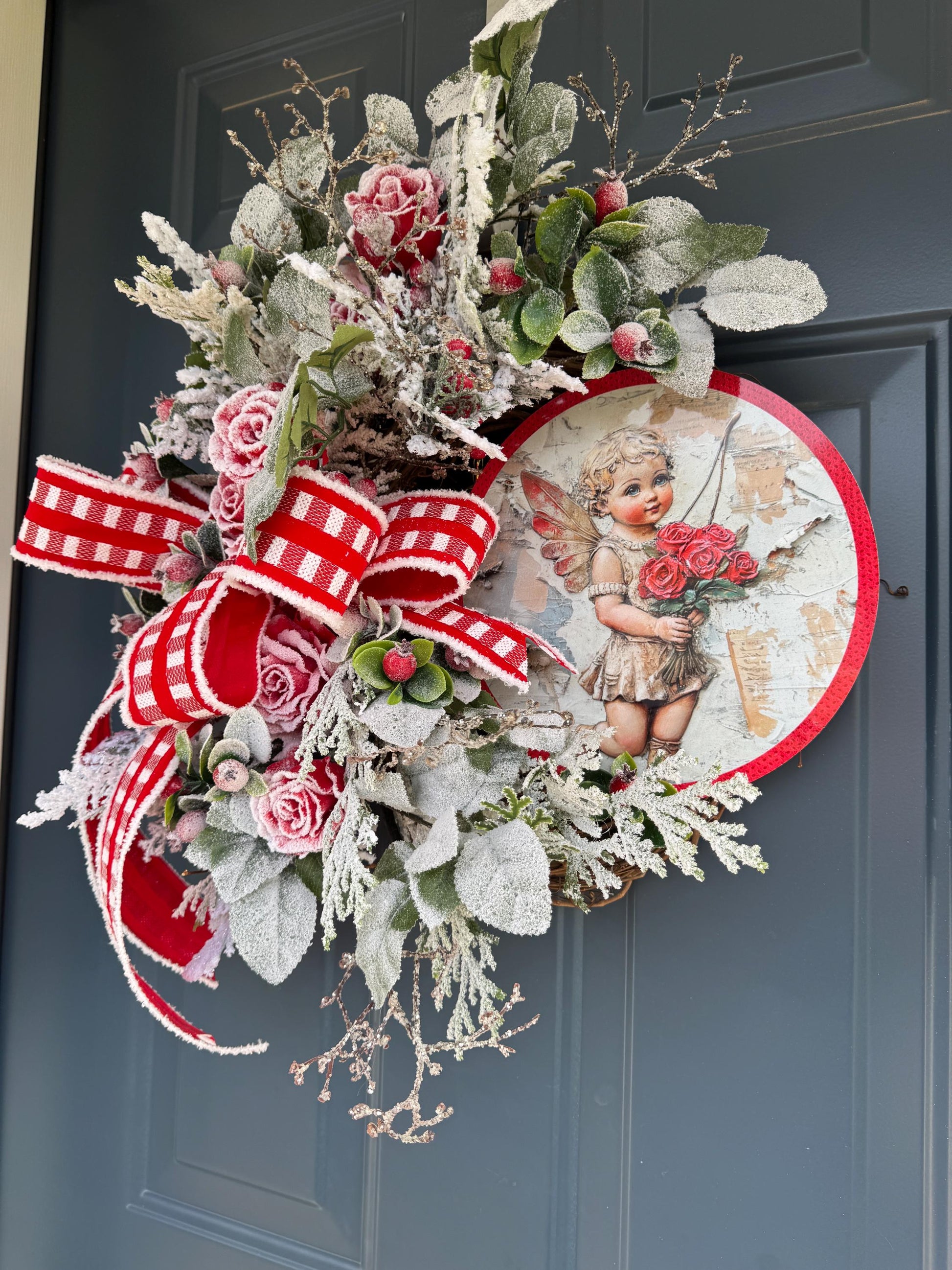 Romantic Valentines Wreath with Cherub Cupid Featuring Snowy Red Roses and Greenery