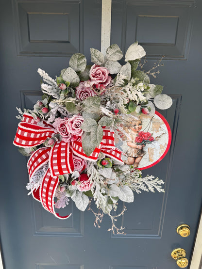 Romantic Valentines Wreath with Cherub Cupid Featuring Snowy Red Roses and Greenery
