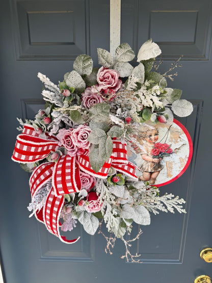 Romantic Valentines Wreath with Cherub Cupid Featuring Snowy Red Roses and Greenery